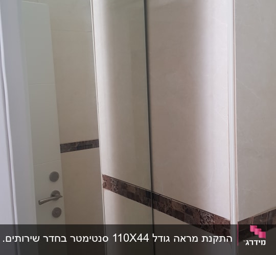 מראה מלבנית על קיר חדר אמבטיה